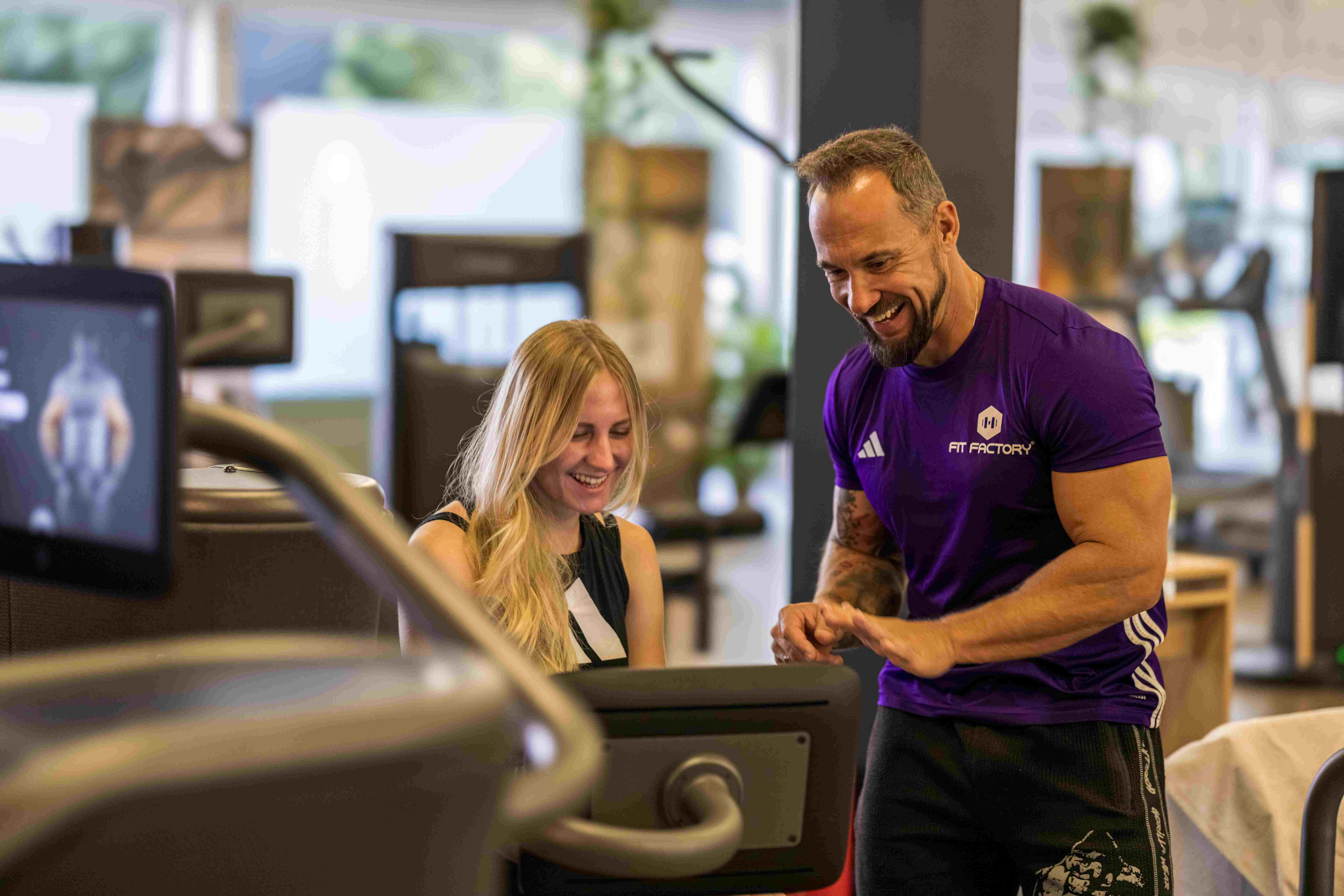 Marc und eine trainierende Frau an einem EGYM-Gerät in der FITfactory